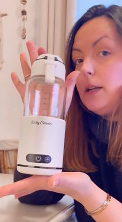 Une maman montre son chauffe-biberon sans fil Babycozidoo à la maison