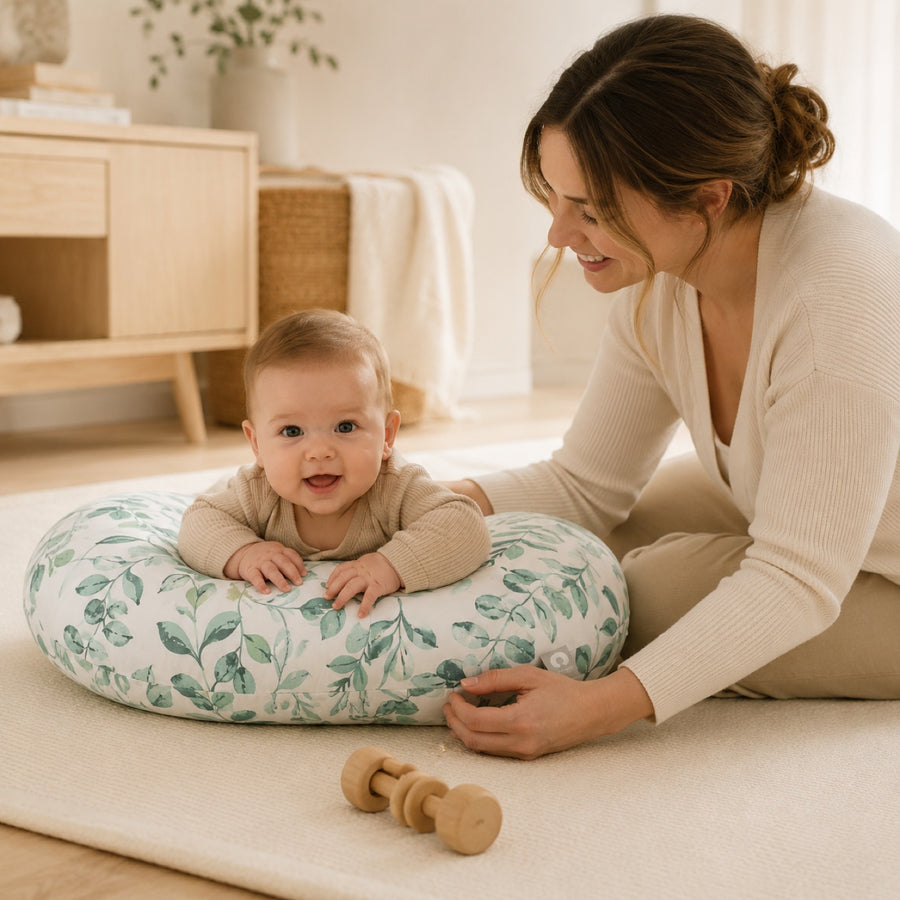 Bébé sur le ventre appuyé sur le coussin Boppy, un adulte tout près