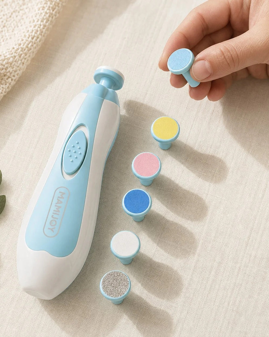 Gros plan sur le coupe-ongles électrique et ses meules posés sur un textile clair