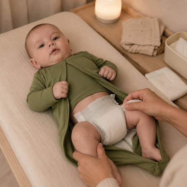 Étape 2 : le buste de bébé reste couvert, seul le bas du pyjama est dégagé pour changer la couche