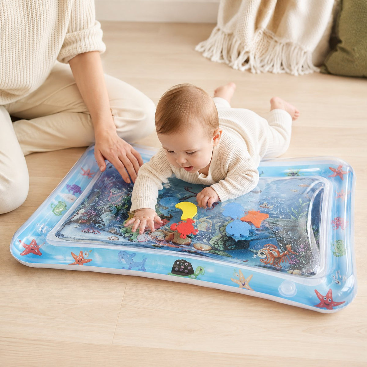 Un parent reste assis à côté du bébé pendant le jeu sur le tapis d'eau, surveillance permanente