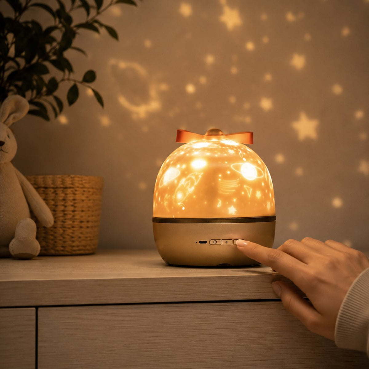 Gros plan sur la veilleuse projecteur d'étoiles et ses boutons de commande, une main règle l'appareil